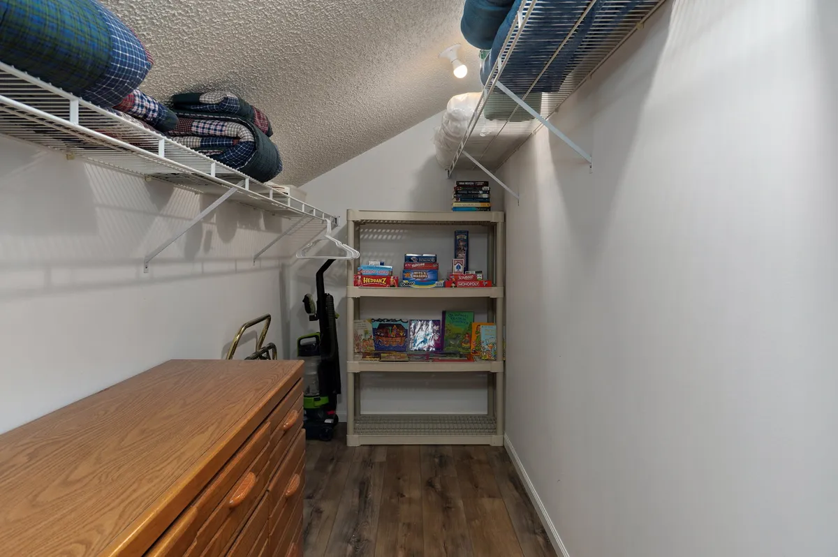 This image showcases a cozy shelving area filled with board games, books, and soft blankets. The scene is practical and organized, suggesting a welcoming spot for quiet play, reading, or family board game sessions.