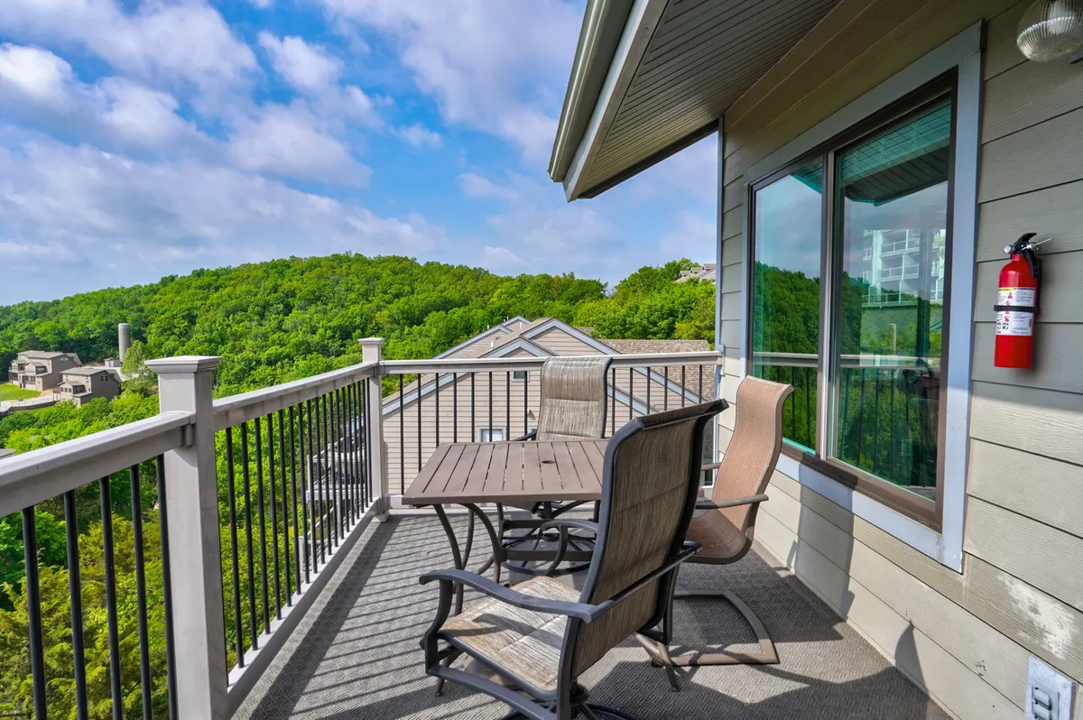 A stylish exterior seating area with a table set for relaxation or casual dining, surrounded by lush green hills. The tranquil outdoor setting is ideal for enjoying morning coffee, entertaining guests, or simply soaking up the peaceful ambiance.